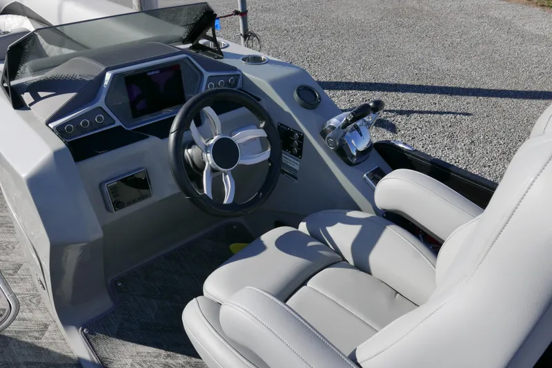 Slide: The Image of 2019 Manitou 25 Encore RF boat cockpit with steering wheel and control panel. - 9