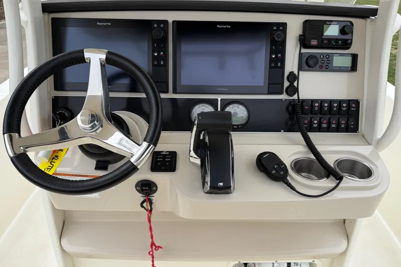 Slide: The Image of Control panel of a 2022 Boston Whaler 270 Dauntless boat with steering wheel and navigation screens. - 16