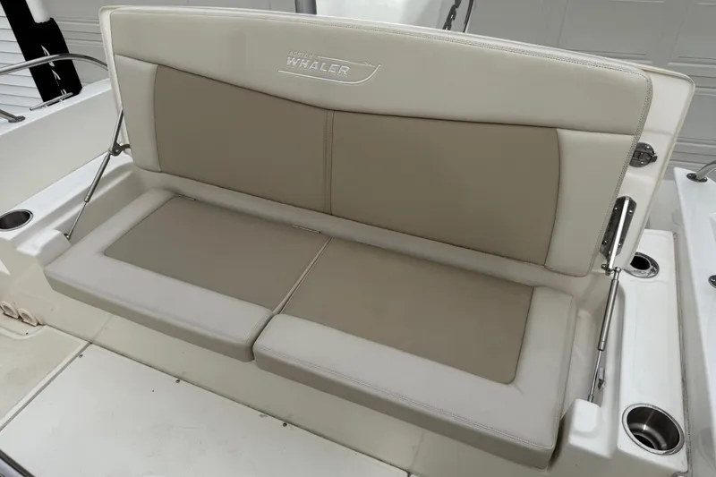 Slide: The Image of 2022 Boston Whaler 270 Dauntless boat seat, beige upholstery, cup holders visible. - 21