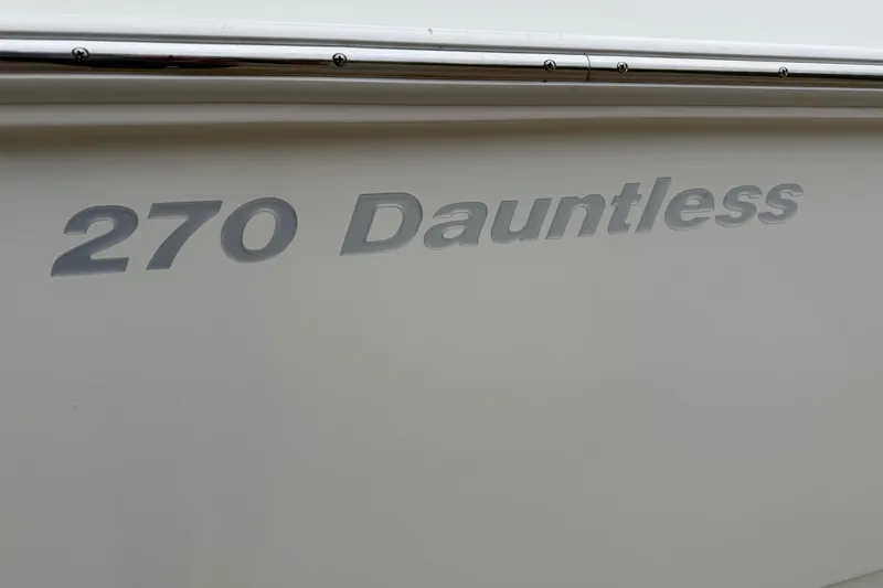 Slide: The Image of 2022 Boston Whaler 270 Dauntless boat nameplate on white hull. - 22