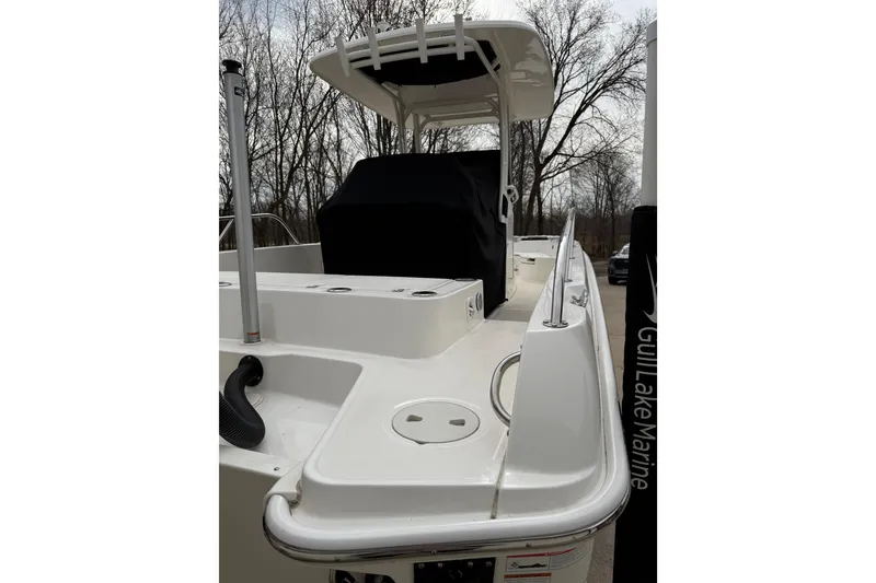 Slide: The Image of 2022 Boston Whaler 270 Dauntless boat, white exterior, docked near trees. - 3