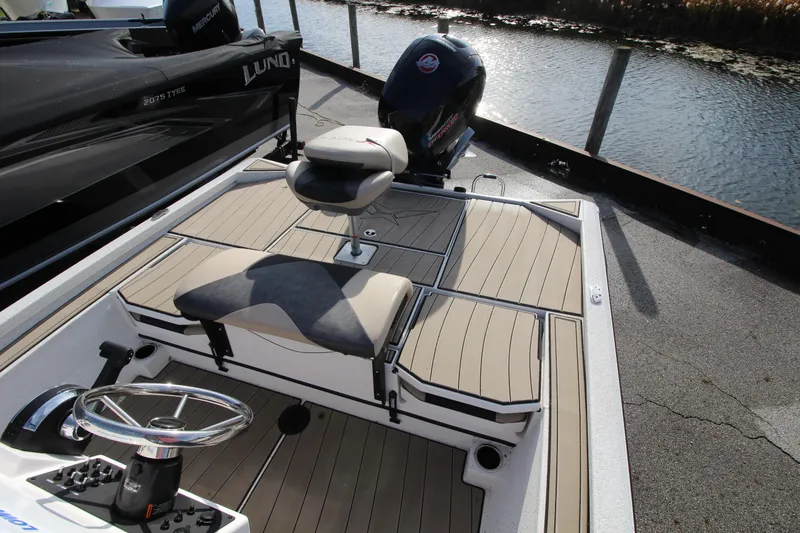 Slide: The Image of 2023 Vexus AVX2180CC boat interior with seating and steering wheel by the water. - 13