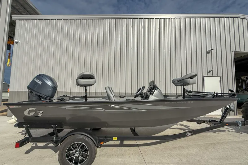 The Image of 2026 G3 Sportsman 1610 boat on trailer, parked outside metal building. - 1