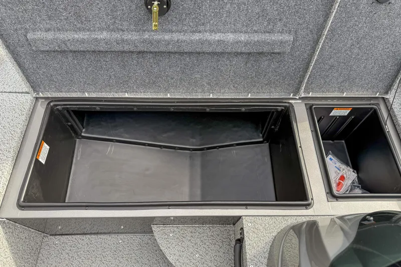 Slide: The Image of 2026 G3 Sportsman 1610 boat storage compartments, open and empty, with gray interior. - 12