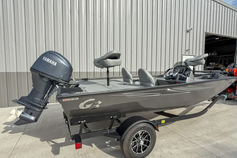 Slide: The Image of 2026 G3 Sportsman 1610 boat with Yamaha motor, parked outside a metal building. - 3