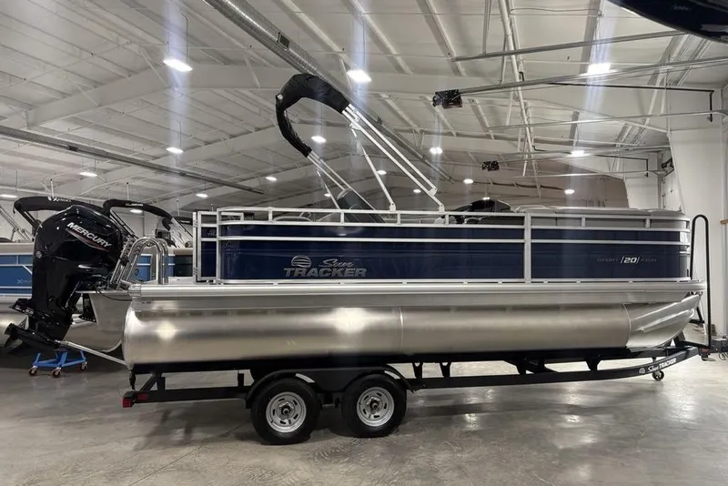 The Image of 2026 Sun Tracker SportFish 20 DLX pontoon boat in a showroom setting. - 1