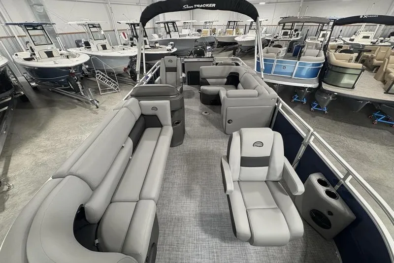 Slide: The Image of 2026 Sun Tracker SportFish 20 DLX pontoon boat interior with gray seating in showroom. - 32