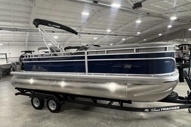 Slide: The Image of 2026 Sun Tracker SportFish 20 DLX pontoon boat in a spacious indoor showroom. - 4