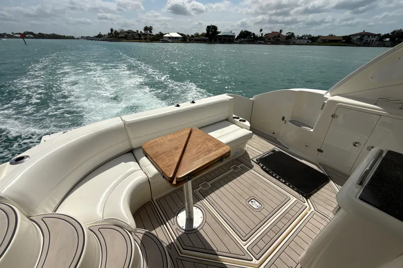 Slide: The Image of 2006 Cruisers Yachts 420 Express boat deck with seating and table on open water. - 15