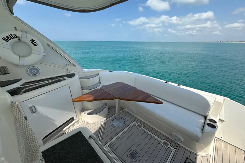 Slide: The Image of 2006 Cruisers Yachts 420 Express deck with ocean view, featuring seating and table. - 18