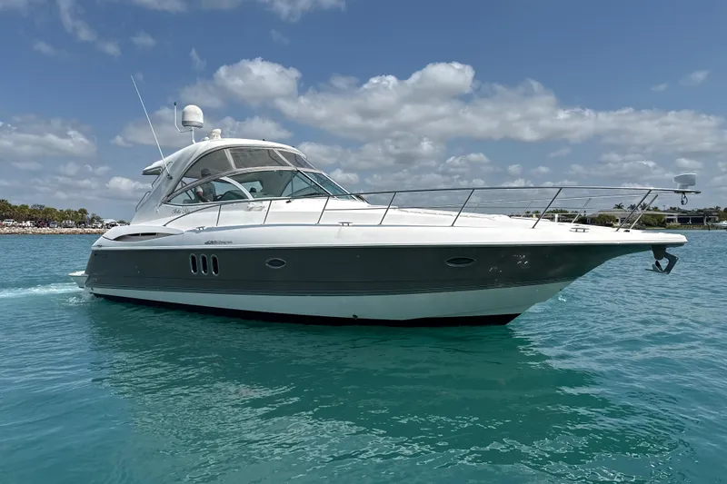 Slide: The Image of 2006 Cruisers Yachts 420 Express on clear blue water under a partly cloudy sky. - 2