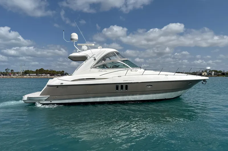 Slide: The Image of 2006 Cruisers Yachts 420 Express on calm water under a partly cloudy sky. - 42