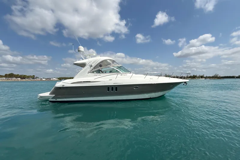 Slide: The Image of 2006 Cruisers Yachts 420 Express on calm blue water under a partly cloudy sky. - 43