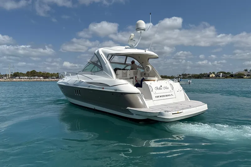 Slide: The Image of 2006 Cruisers Yachts 420 Express on clear blue water under a partly cloudy sky. - 44