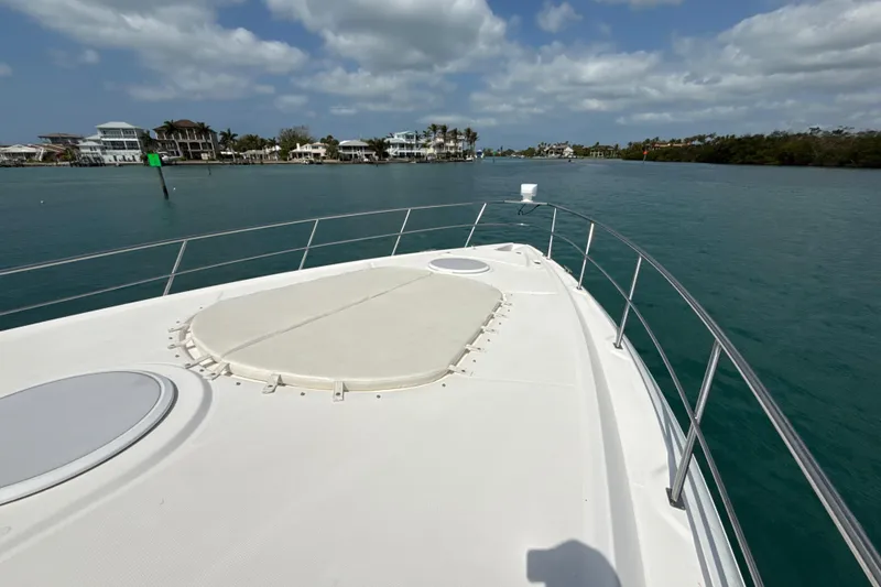 Slide: The Image of 2006 Cruisers Yachts 420 Express on calm water, with coastal homes in the background. - 45