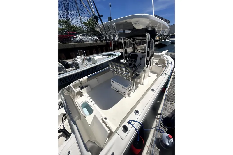Slide: The Image of 2023 Key West 239 FS boat docked, featuring spacious deck and modern controls. - 11