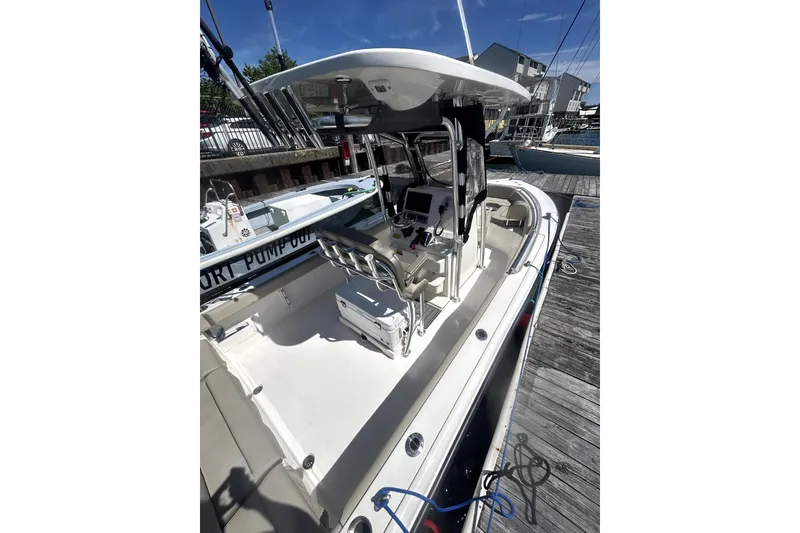 Slide: The Image of 2023 Key West 239 FS boat docked, featuring a spacious deck and modern console. - 13