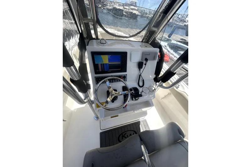 Slide: The Image of 2023 Key West 239 FS boat cockpit with steering wheel and navigation display. - 15