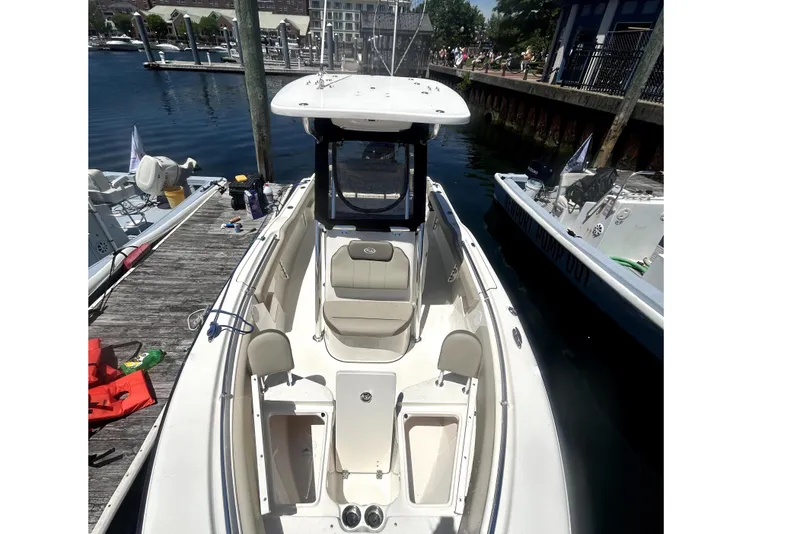 Slide: The Image of 2023 Key West 239 FS boat docked at marina, showcasing spacious seating and sleek design. - 8