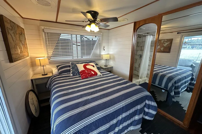 Slide: The Image of Cozy bedroom in 1996 Lazy Days houseboat with striped bedding and nautical decor. - 12