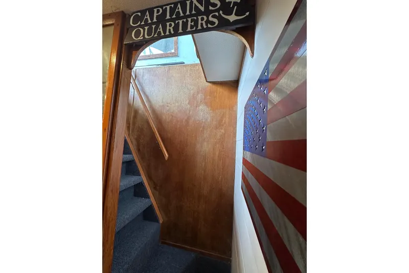 Slide: The Image of Staircase leading to Captain's Quarters on 1996 Lazy Days houseboat, with American flag decor. - 15