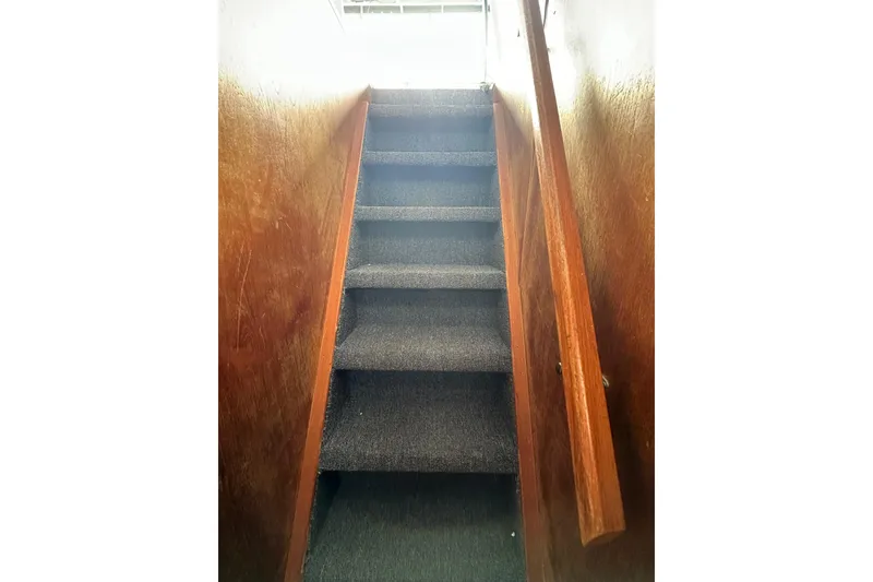 Slide: The Image of Carpeted stairs with wooden handrails in a 1996 Lazy Days 15x64 model. - 16