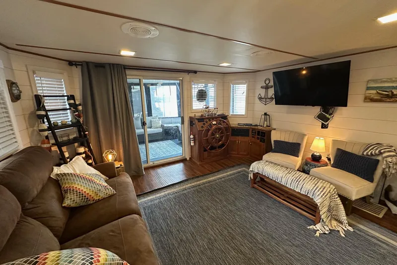 Slide: The Image of Cozy 1996 Lazy Days houseboat interior with nautical decor, plush seating, and large TV. - 5