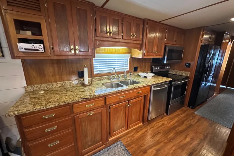Slide: The Image of Spacious kitchen in 1996 Lazy Days model, featuring wooden cabinets and granite countertops. - 6