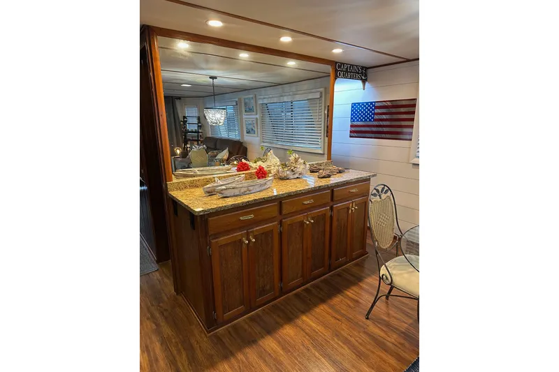Slide: The Image of Luxurious 1996 Lazy Days houseboat interior with wooden cabinetry and American flag decor. - 7