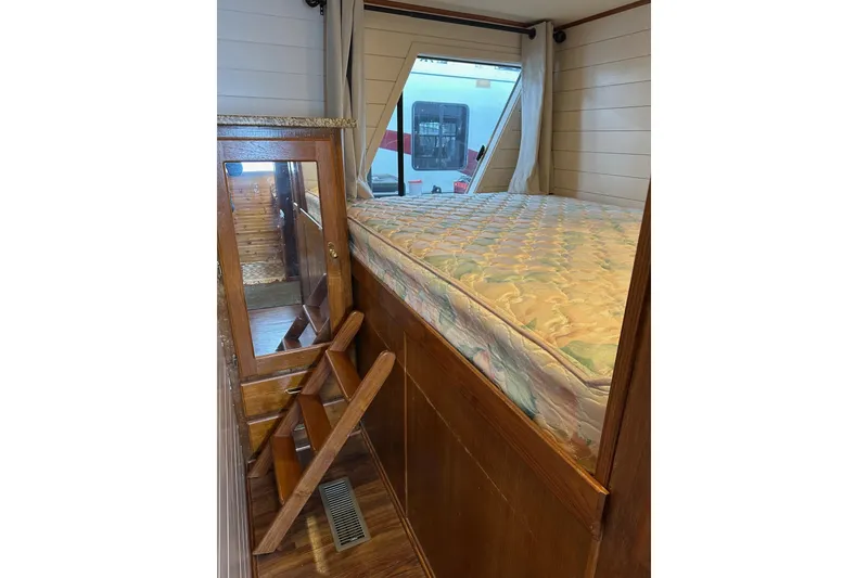 Slide: The Image of Interior of 1996 Lazy Days 15x64 RV with elevated bed and wooden ladder. - 9