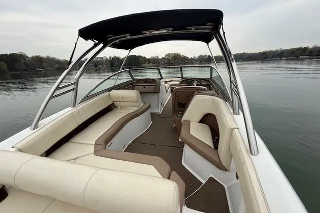 Slide: The Image of 2010 Cobalt 276 boat interior with beige seating on a calm lake. - 10