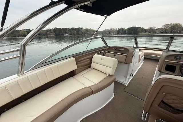 Slide: The Image of 2010 Cobalt 276 boat interior with beige seating, overlooking a serene lake. - 14