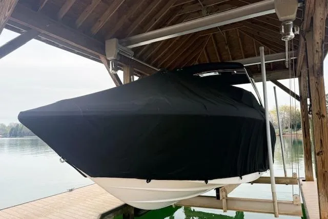 Slide: The Image of 2010 Cobalt 276 boat covered and docked under a wooden shelter by the lake. - 4