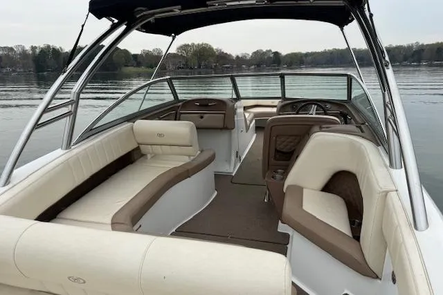Slide: The Image of 2010 Cobalt 276 boat interior with beige seating on a calm lake. - 7