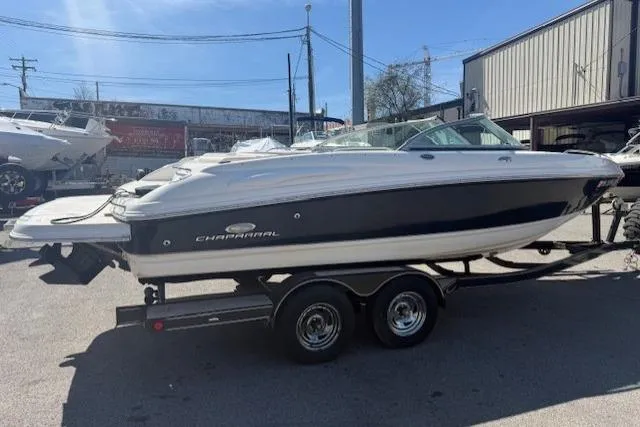 Slide: The Image of 2006 Chaparral 220 SSi boat on trailer, parked outdoors in a marina setting. - 3