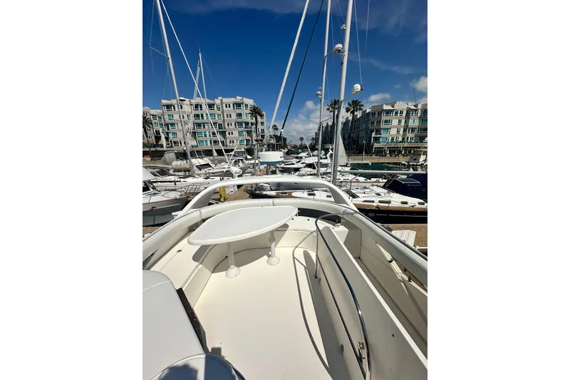 Slide: The Image of 2002 Fairline 50 yacht docked in marina, surrounded by sailboats and modern buildings. - 17