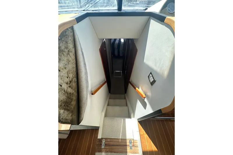 Slide: The Image of Stairway inside 2002 Fairline 50 yacht, featuring wooden accents and carpeted steps. - 18