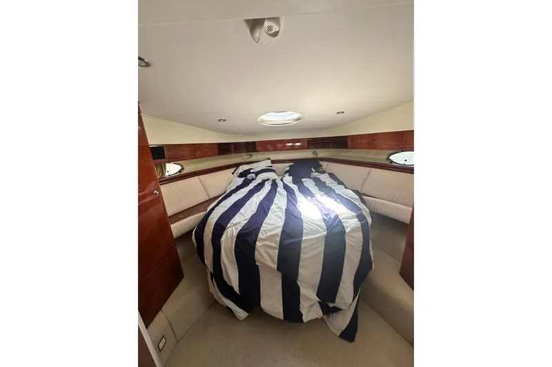 Slide: The Image of Luxurious cabin interior of 2002 Fairline 50 yacht with striped bedding and wood accents. - 19
