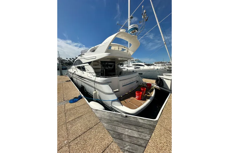 Slide: The Image of 2002 Fairline 50 yacht docked at marina under clear blue sky. - 6