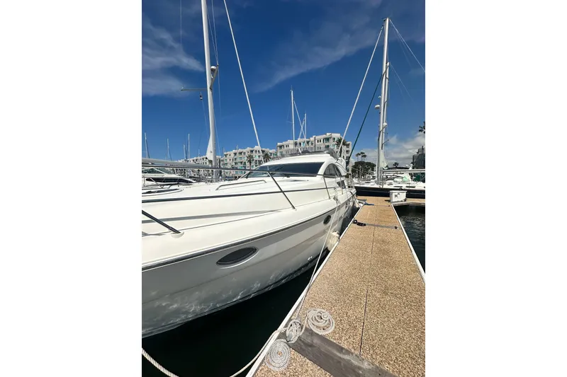 Slide: The Image of Luxury Fairline 50 yacht docked at marina, 2002 model under clear blue sky. - 7