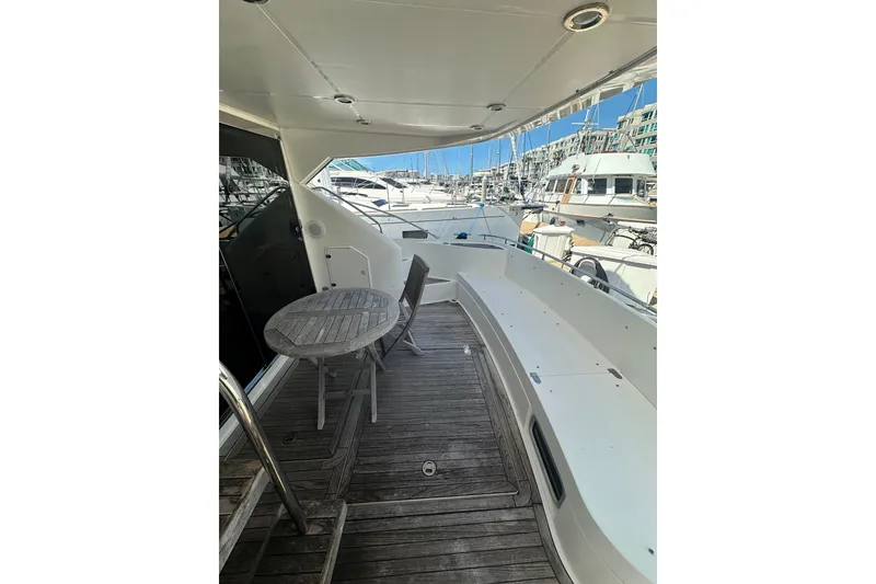 Slide: The Image of 2002 Fairline 50 yacht deck with seating and table, docked at marina. - 8