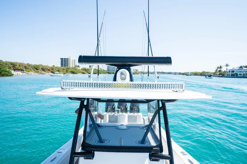 Slide: The Image of Invincible 36 Open Fisherman 2020 on blue water with cityscape in background. - 13