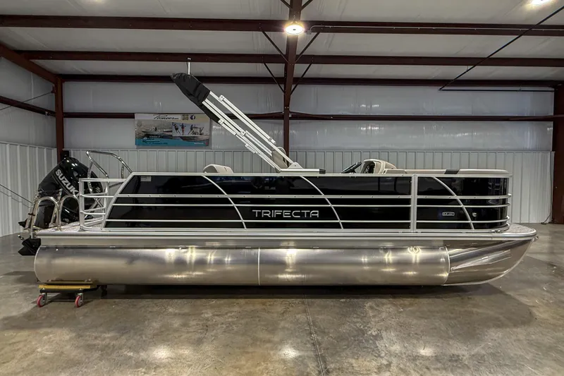 Slide: The Image of 2025 Trifecta 22UL LE pontoon boat in a spacious indoor storage facility. - 6