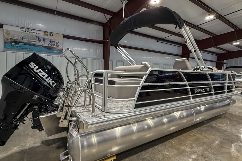 Slide: The Image of 2025 Trifecta 22UL LE pontoon boat with Suzuki outboard motor in showroom. - 8
