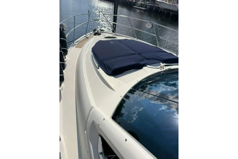 Slide: The Image of 2009 Cranchi Mediterranee 43 yacht deck with blue cover, reflecting sky and water. - 2