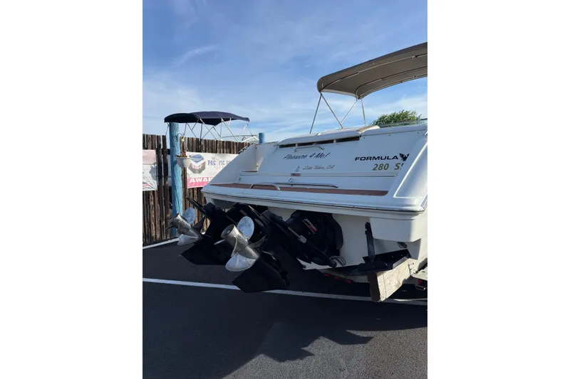 Slide: The Image of 1999 Formula 280 Sun Sport boat with dual propellers, parked outdoors. - 7