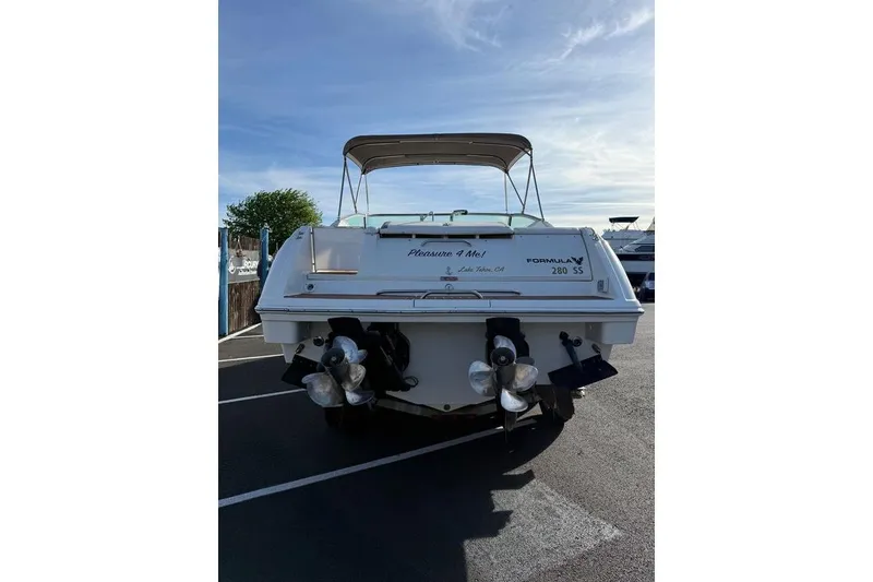 Slide: The Image of 1999 Formula 280 Sun Sport boat, rear view, parked on asphalt under clear sky. - 8