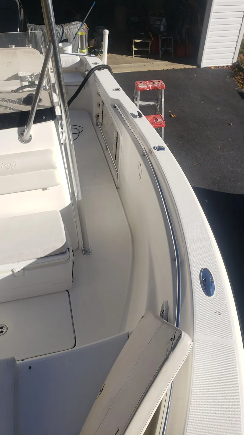 Slide: The Image of 2009 Triton 225 CC boat interior, white seats and deck. - 18