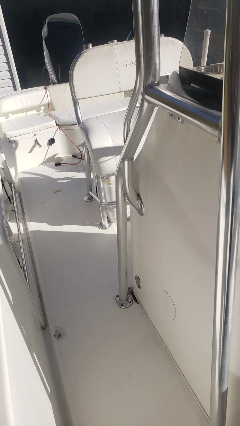 Slide: The Image of Interior view of a 2009 Triton 225 CC boat with white seating. - 21