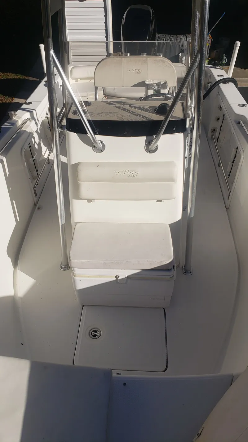 Slide: The Image of Interior view of a 2009 Triton 225 CC boat with seating area. - 23